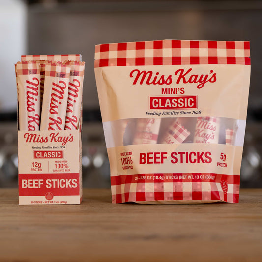 The Miss Kay's Family Bundle: a Classic beef sticks box and a Classic Mini bag together on a wooden counter