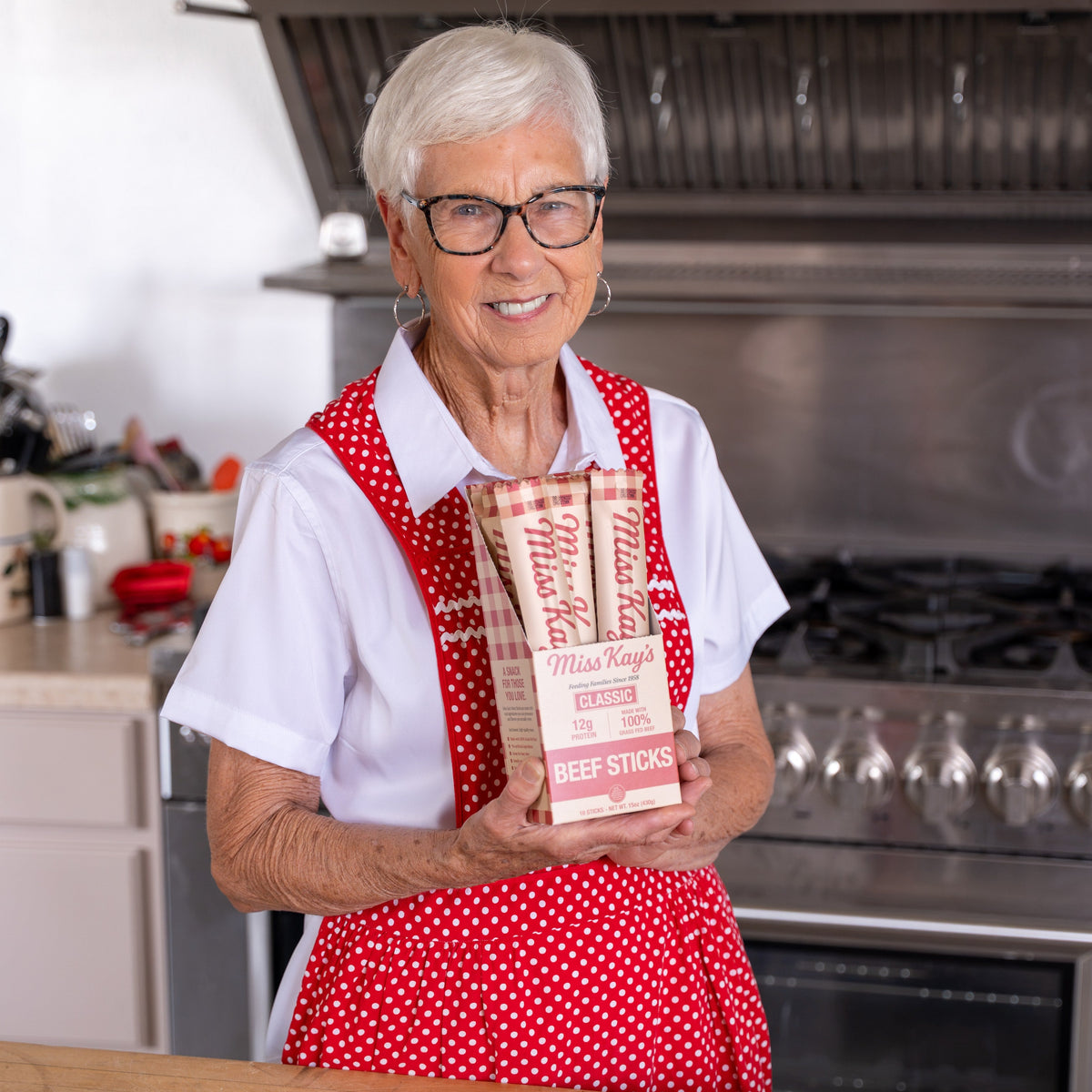 Miss Kay seasoning a batch of grass-fed beef sticks in her kitchen